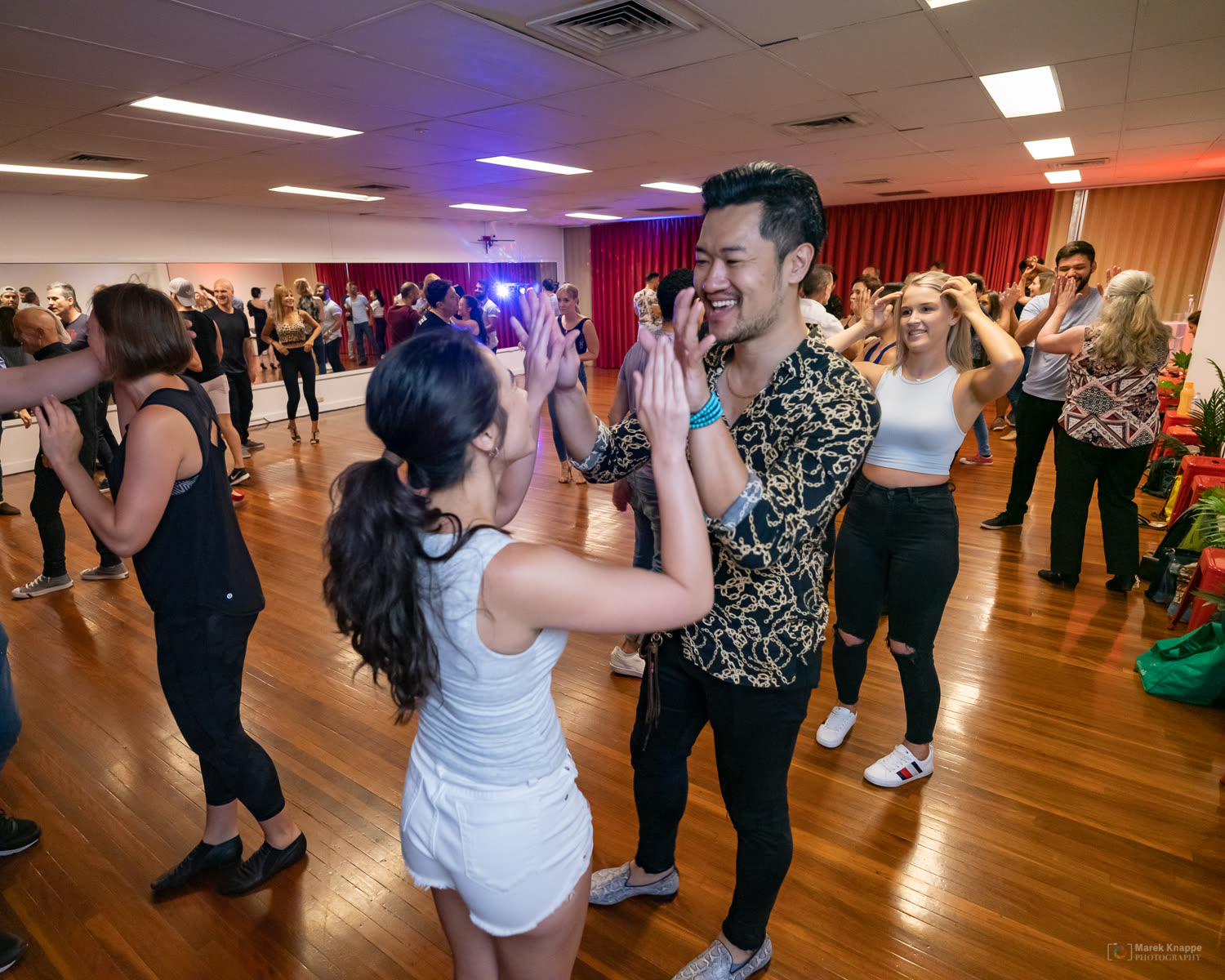 A full Introduction to Latin Dancing class high-fiving and changing partners