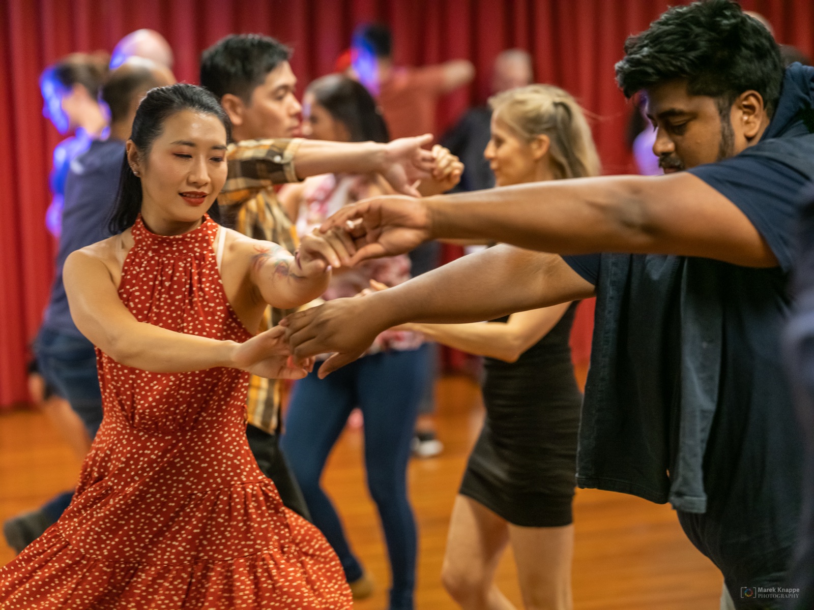 A pair mid-spin dancing Salsa in a red dress
